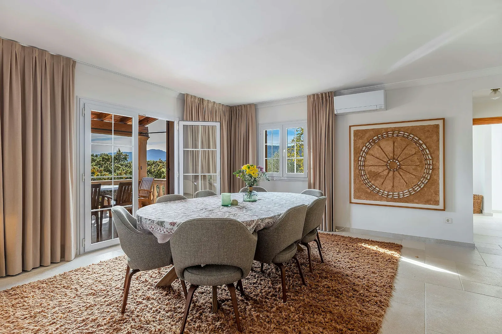 Villa Scarlett indoor dining area next to patio doors opening onto the terrace, emphasizing natural light and views. Luxury dining ByMilagro.