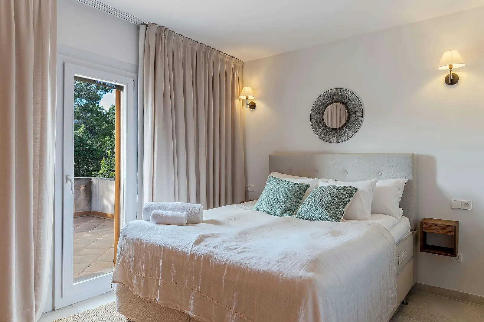 Bright, modern master bedroom in luxury villa for rent. Comfortable double bed, balcony access, and elegant neutral decor. ByMilagro property.