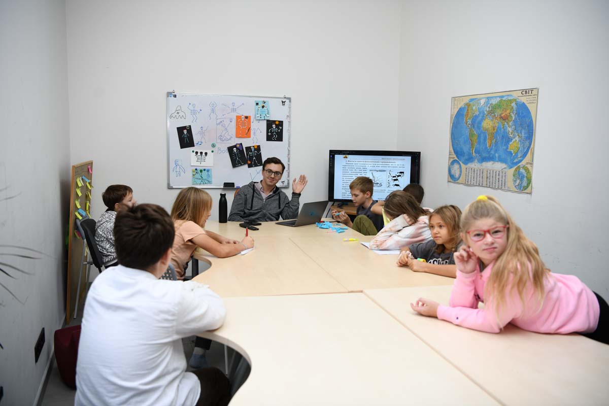 Учні середньої школи за кругим столом на занятті з історії