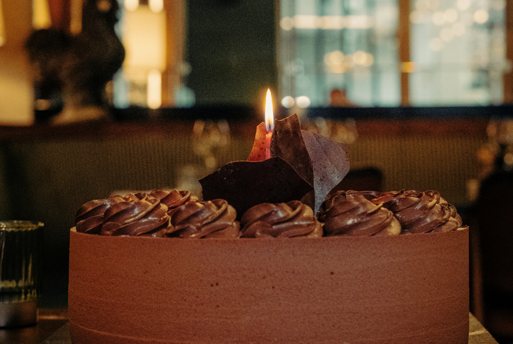 Gâteau d'anniversaire avec bougie posé sur une table à la brasserie de grand messe