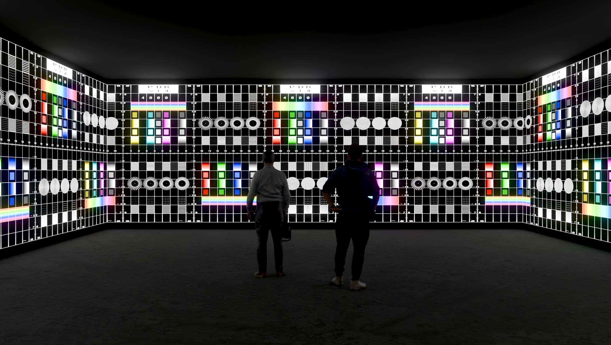 Two A/V specialists in an immersive room observing a room being 3D mapped.