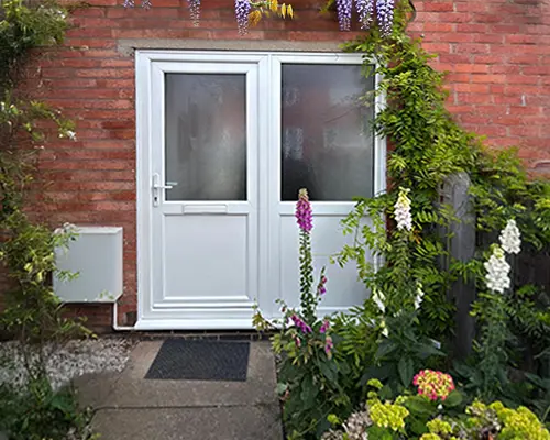 upvc doors in a red brick house surrounded by foliage