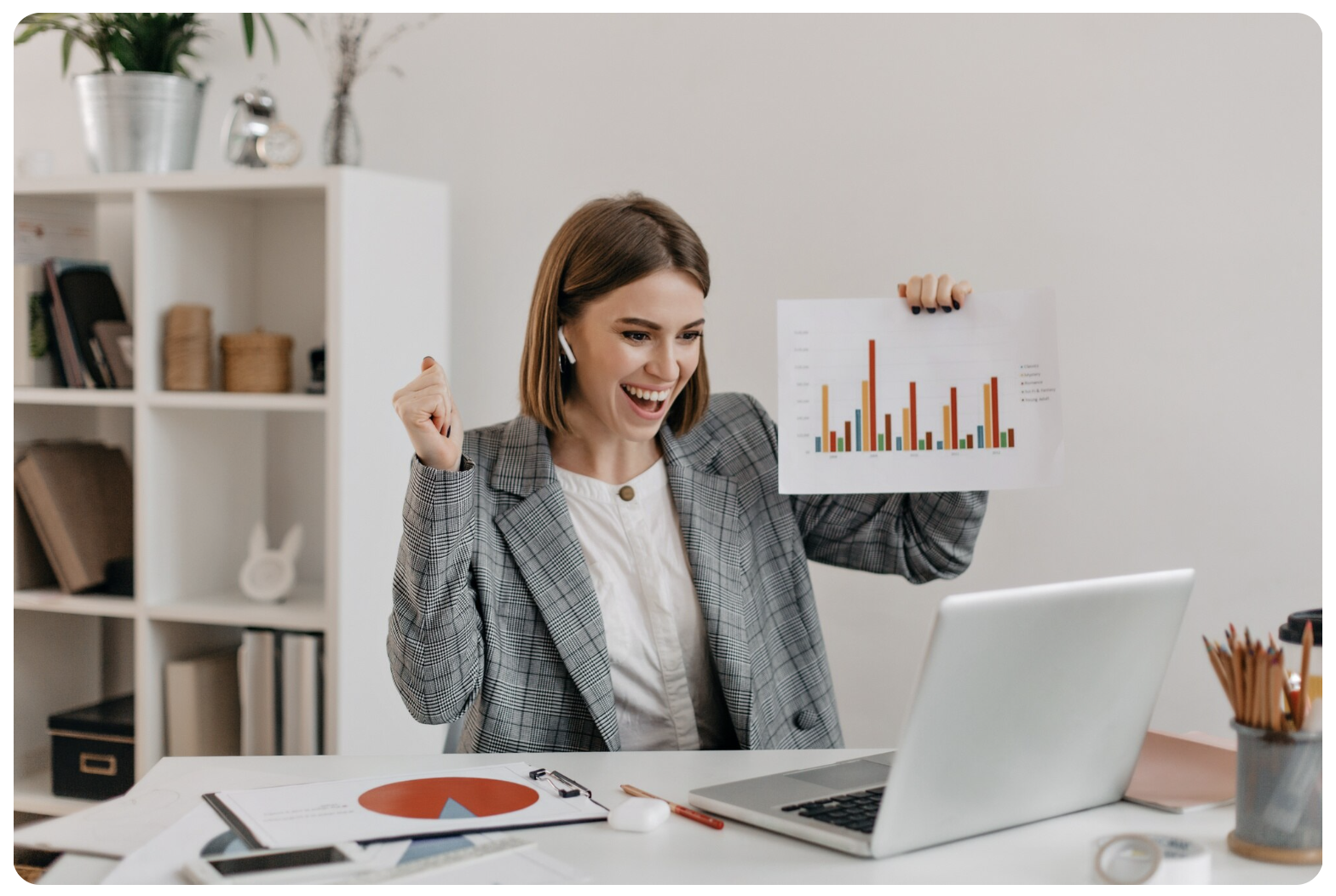 Businesswoman with confidence to see the green ascending graph lines on her computer monitor, celebrating successful sales enablement results. 