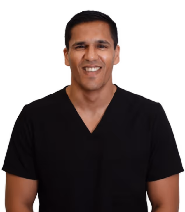 Smiling man wearing a black V-neck shirt against a black background.