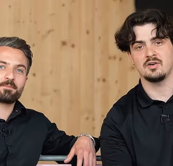 Zwei Männer auf einer Bank erklären SEA & SEO. Mauro und Moreno – Google Ads Agentur