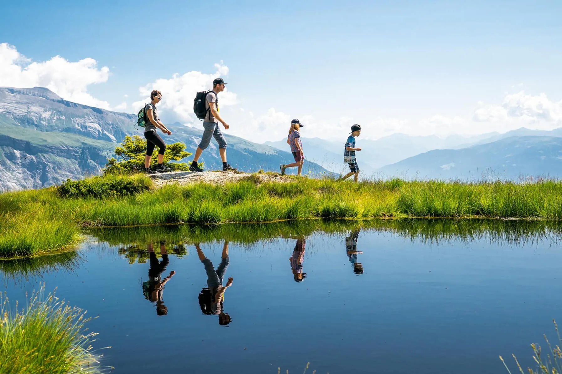 Familie bei Sommerwanderung in den Bergen von LAAX im Rahmen der CONCORDIA Ferienkampagne