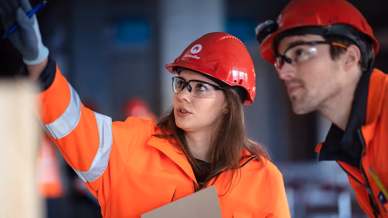 Technische Fachkräfte von Schindler mit Sicherheitsausrüstung bei der Aufzugmodernisierung