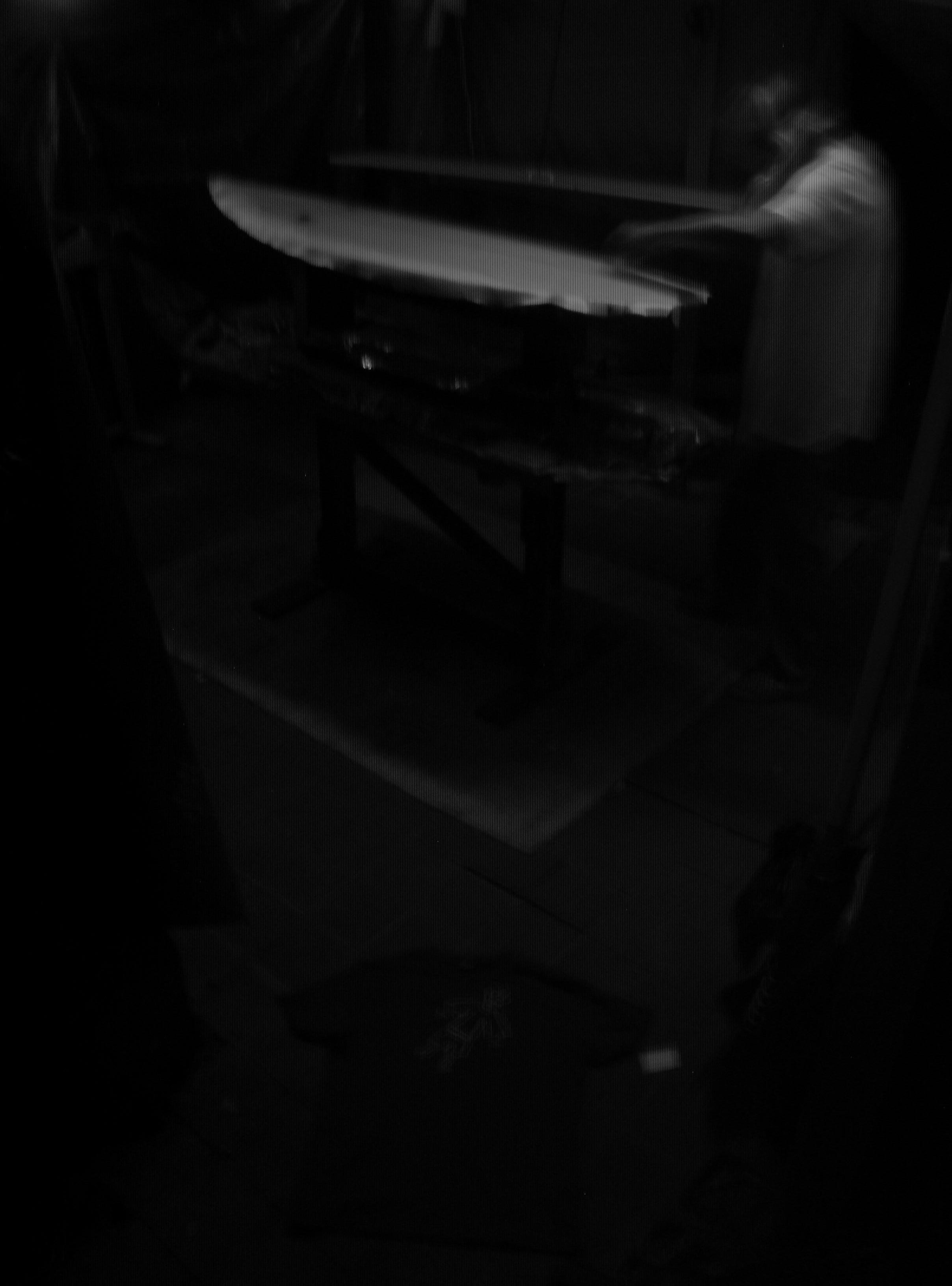 A person sitting at a table in a dark room.