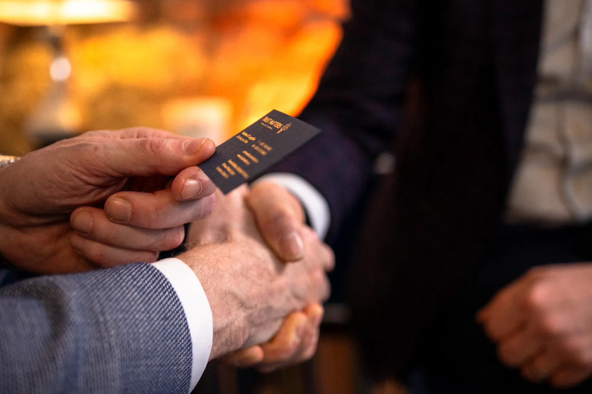 Men shaking hands and exchanging a business card.