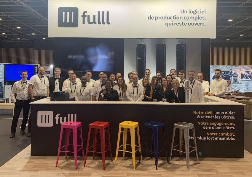 un groupe de personnes qui posent devant un stand