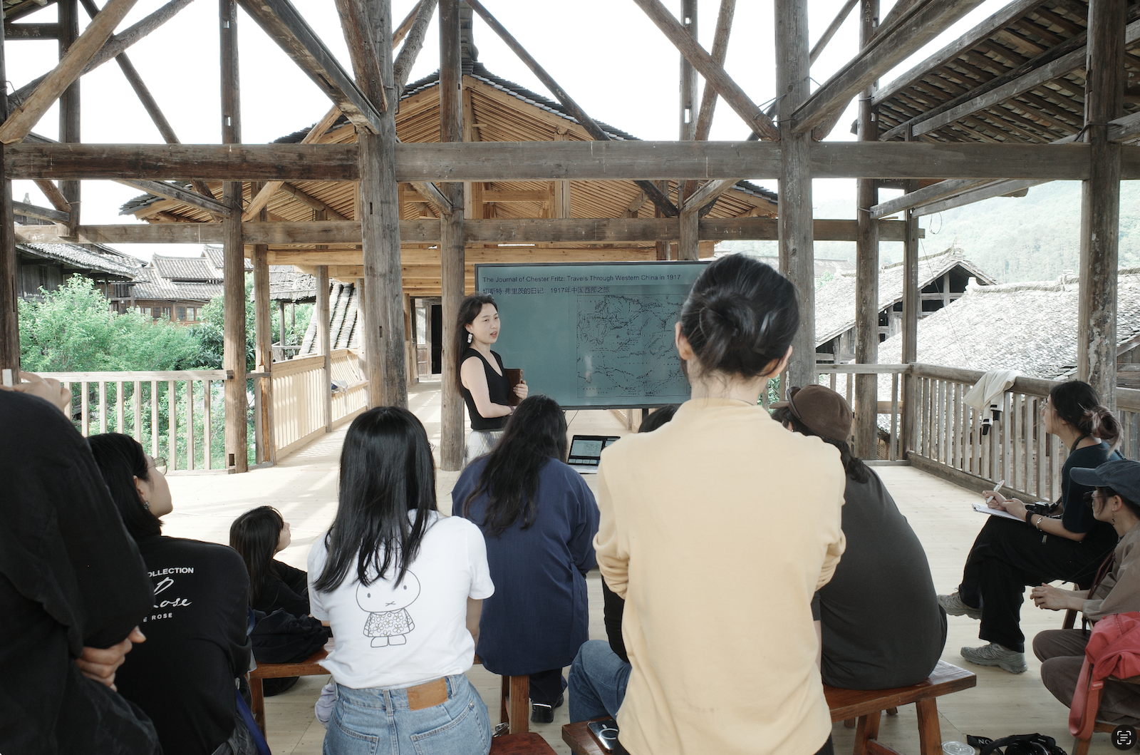 Artist Zike He giving a presentation at Baopu·FELT’s partner venue in a Miao village (苗寨) in Shidong (施洞), as part of Language in Action (语言行动): A Peer Learning Retreat, 2026. Courtesy of Baopu·FELT.
