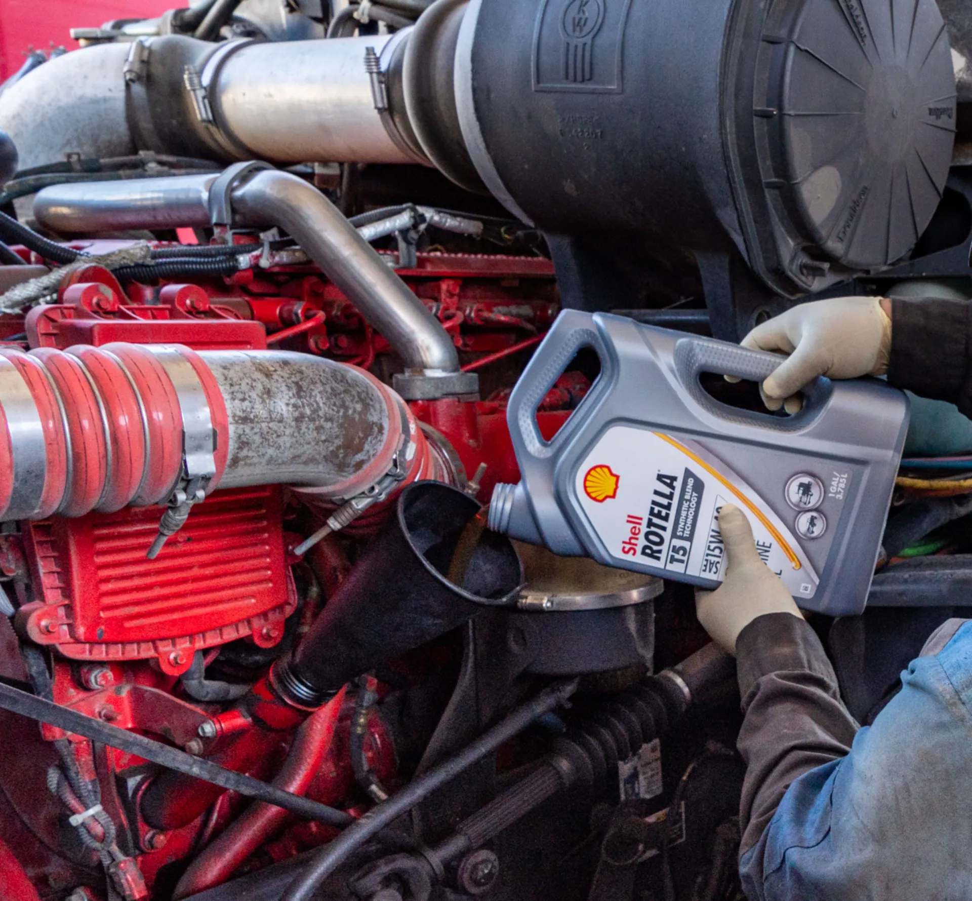 Heavy-duty mechanic performing oil & fluid service on semi truck