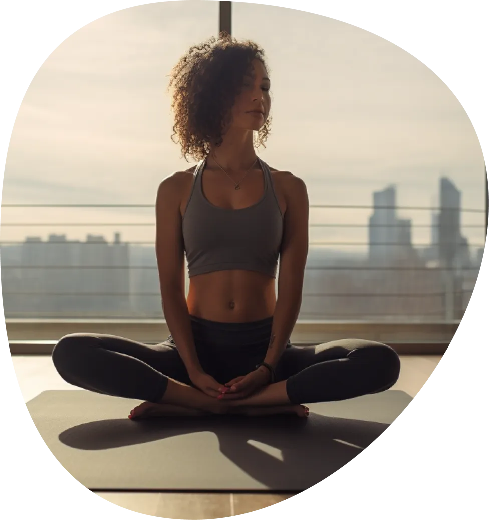 A woman doing a stretching yoga pose in front of a window