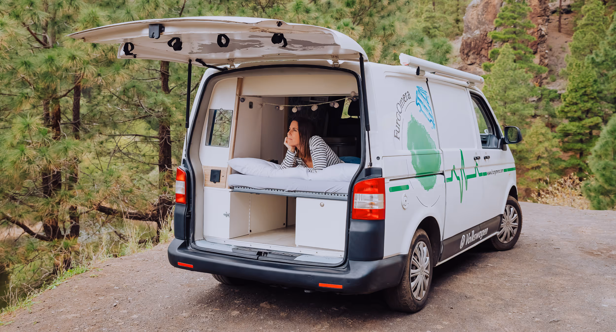 Vista trasera de la camper La Guancha con el portón abierto en un entorno natural