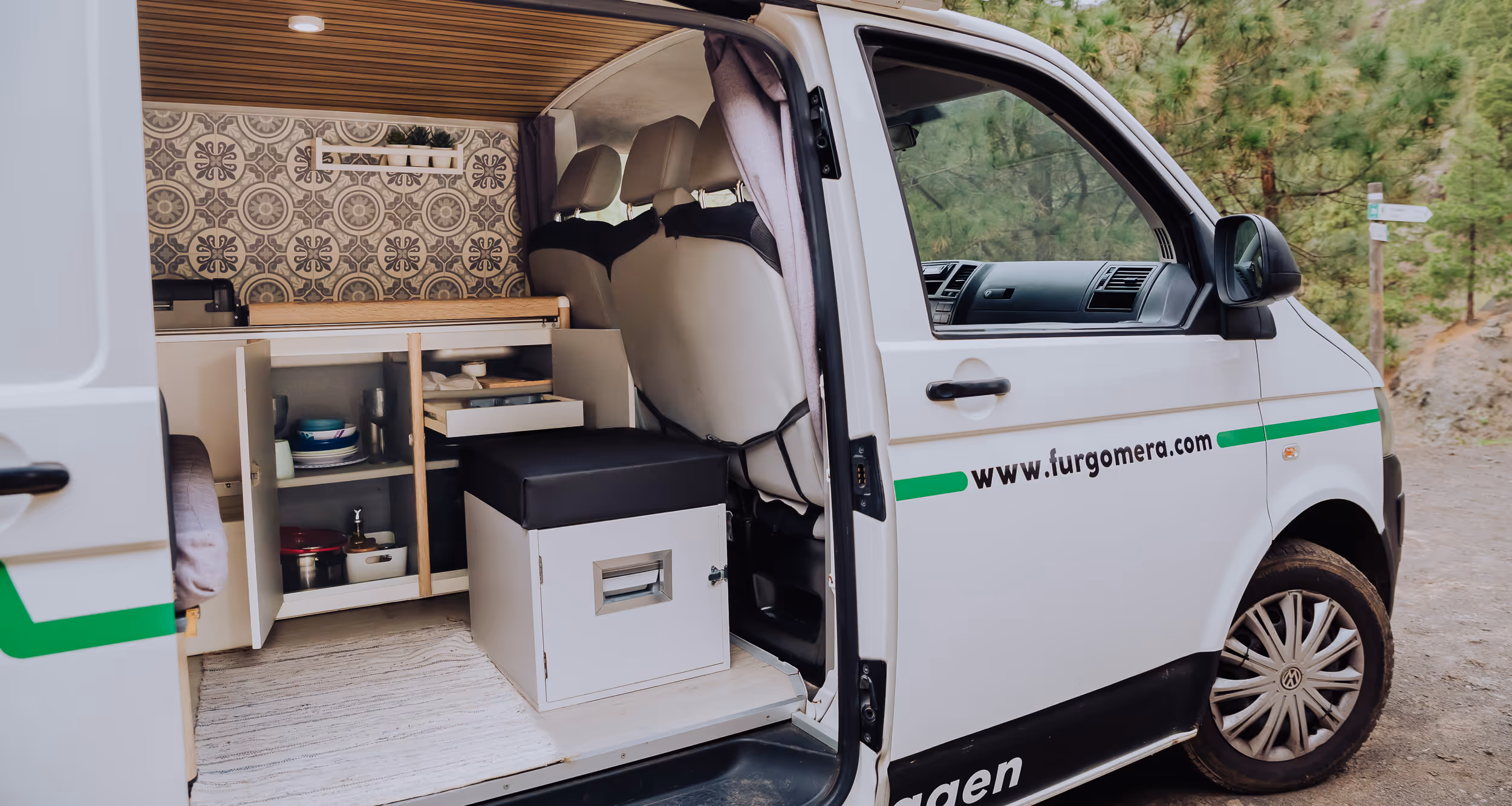 Interior de la camper La Guancha con puerta corredera abierta y mobiliario