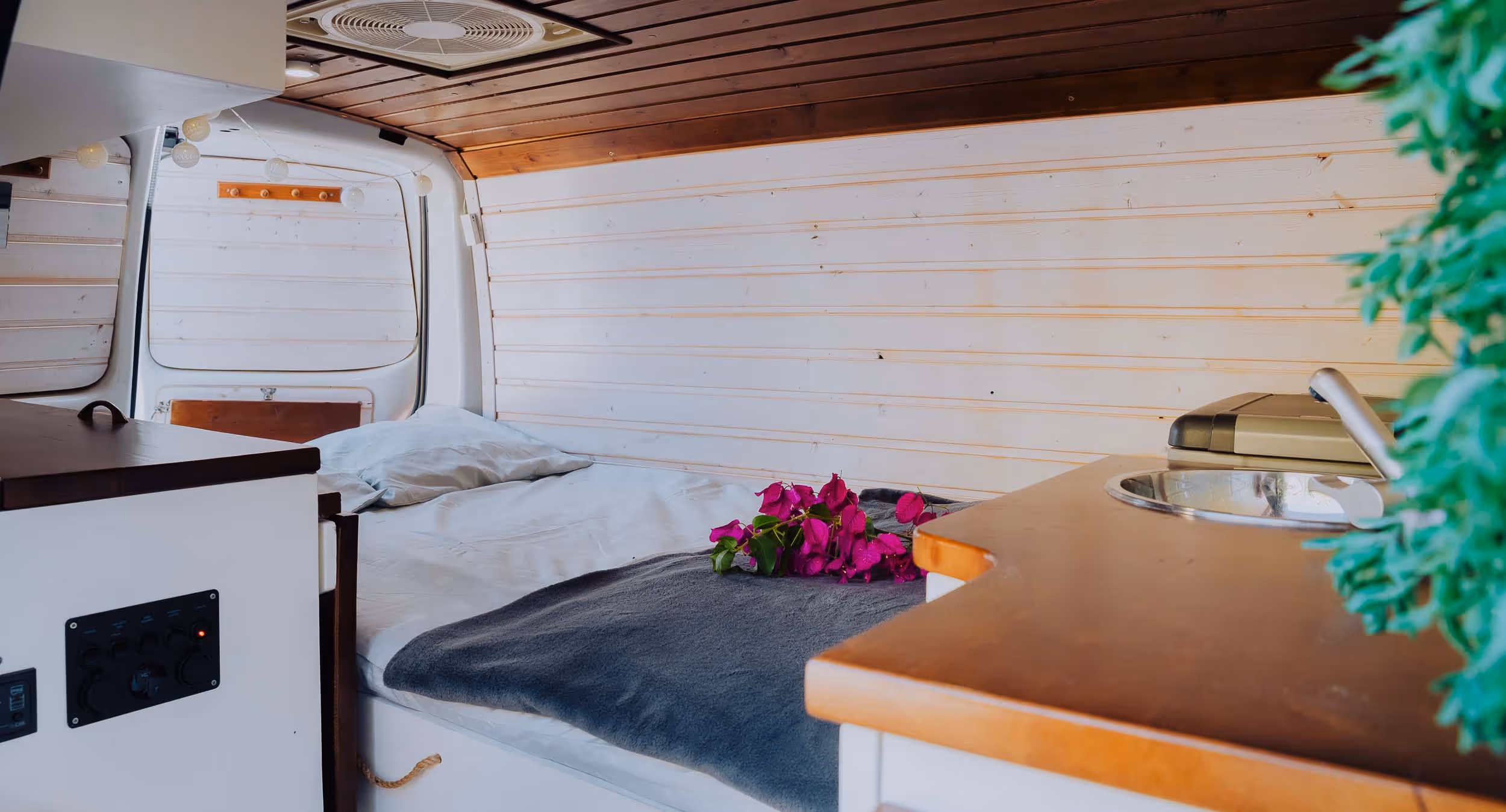 Interior de la camper Majona con zona de cama y encimera.