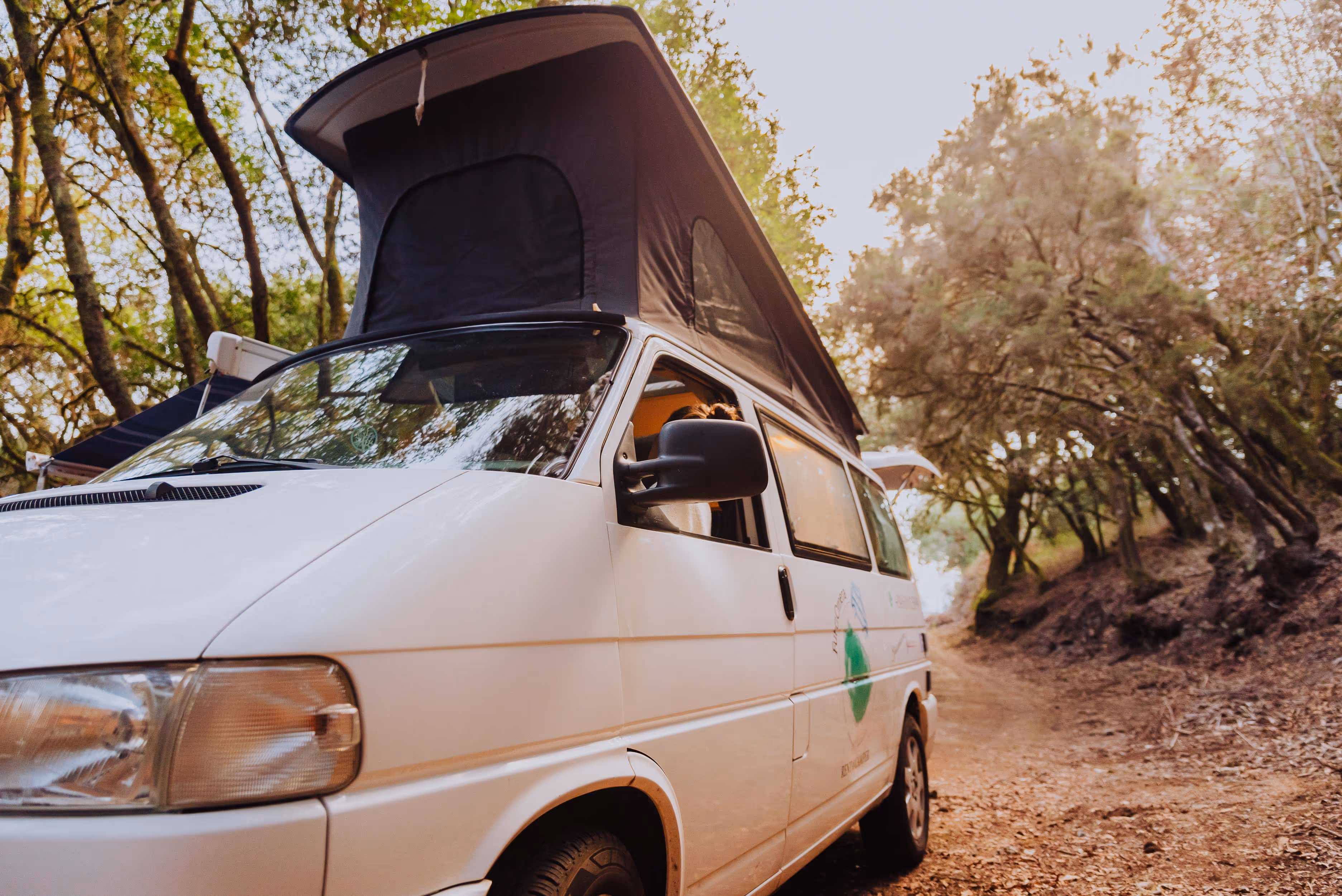 Camper Agana con techo elevable abierto en un entorno natural.