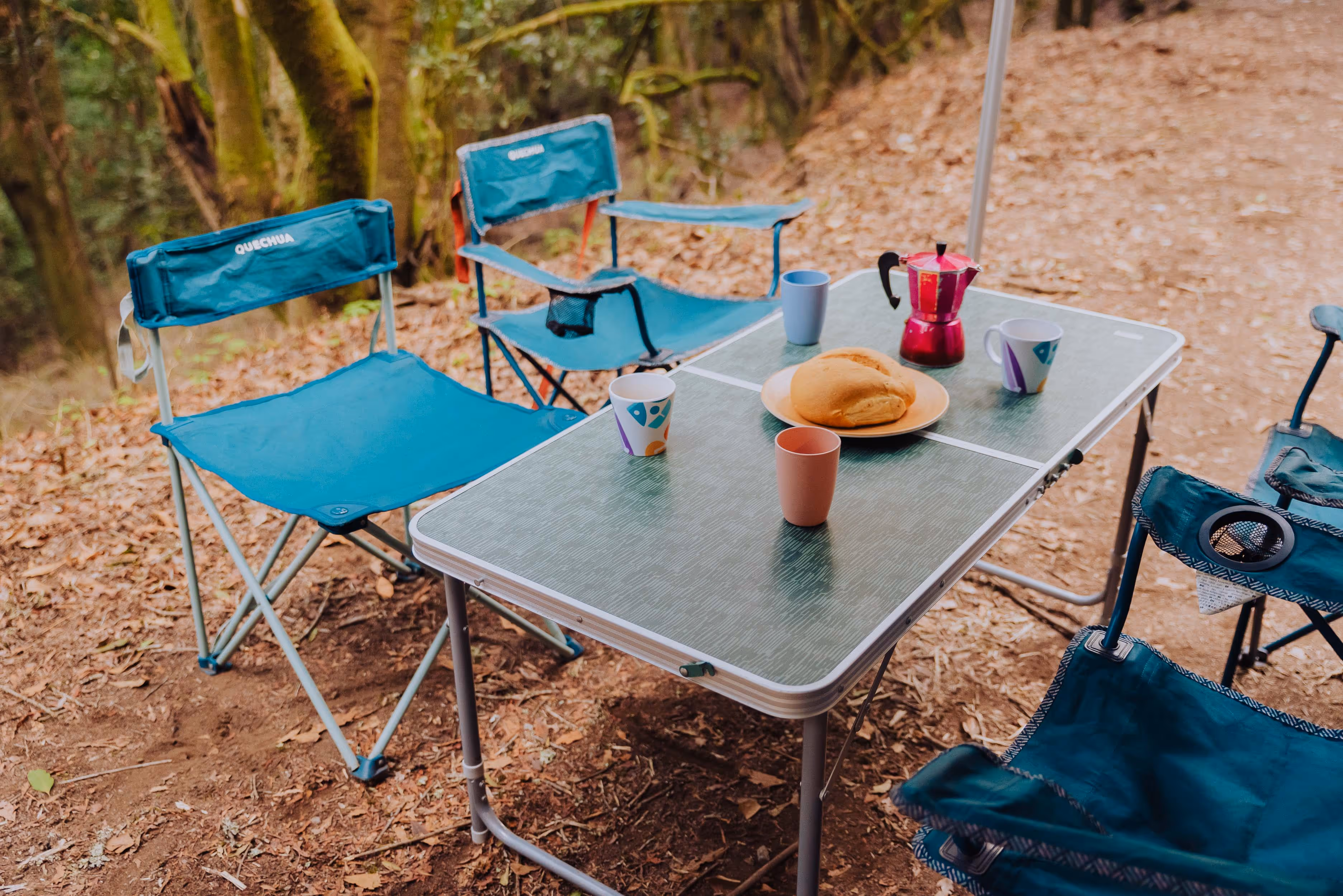 Mesa de camping con sillas junto a la camper Agana.