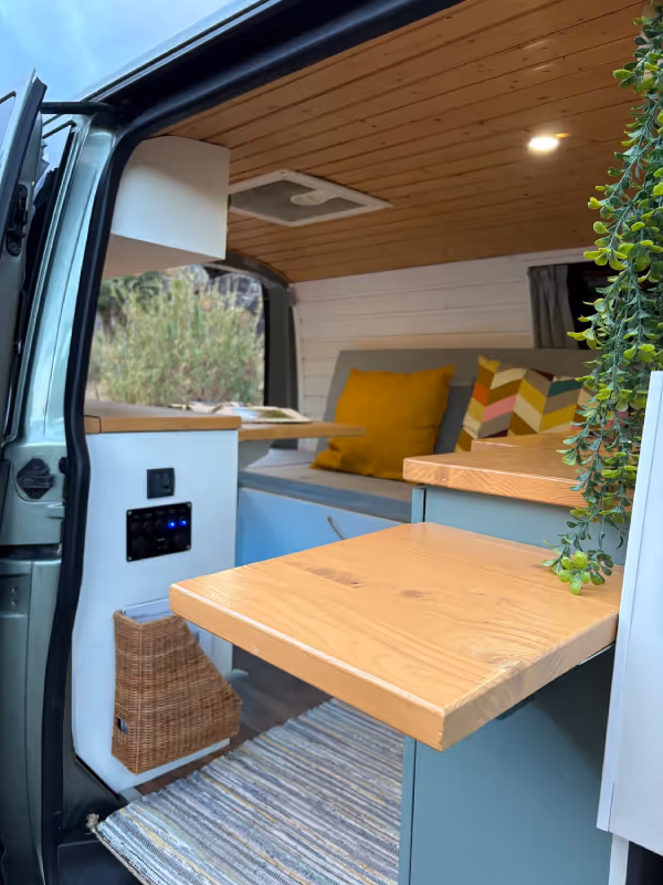 Mesa plegable y zona de estar en el interior de la camper Avalo.”