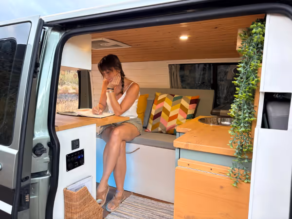 Interior de la camper Avalo con una persona sentada en la zona de estar.