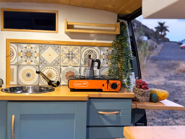Cocina de la camper Avalo con fogón portátil, fregadero y zona de trabajo.