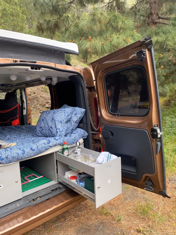 Parte trasera de la camper Arguamul con cama montada y módulo de cocina.