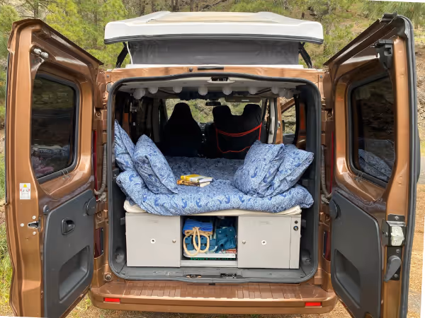 Parte trasera de la camper Arguamul con la cama montada y espacio de almacenamiento.