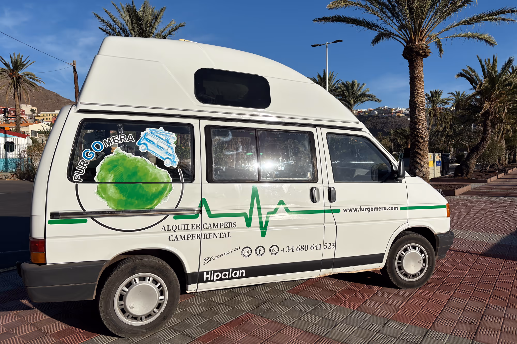 Camper Hipalán de Furgomera aparcada en una zona urbana con palmeras en La Gomera.