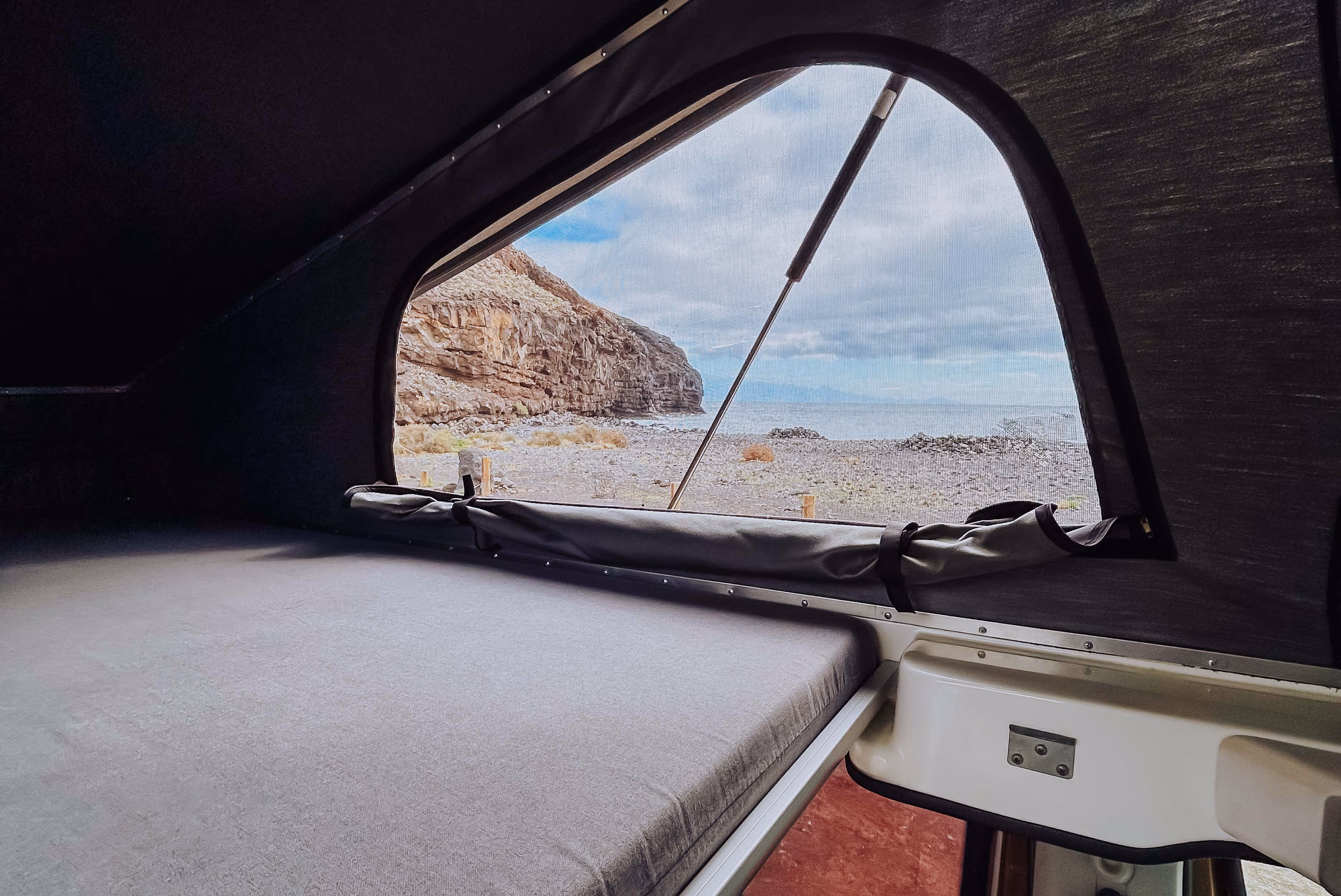 Vista desde la cama superior de la camper Arguamul hacia la costa