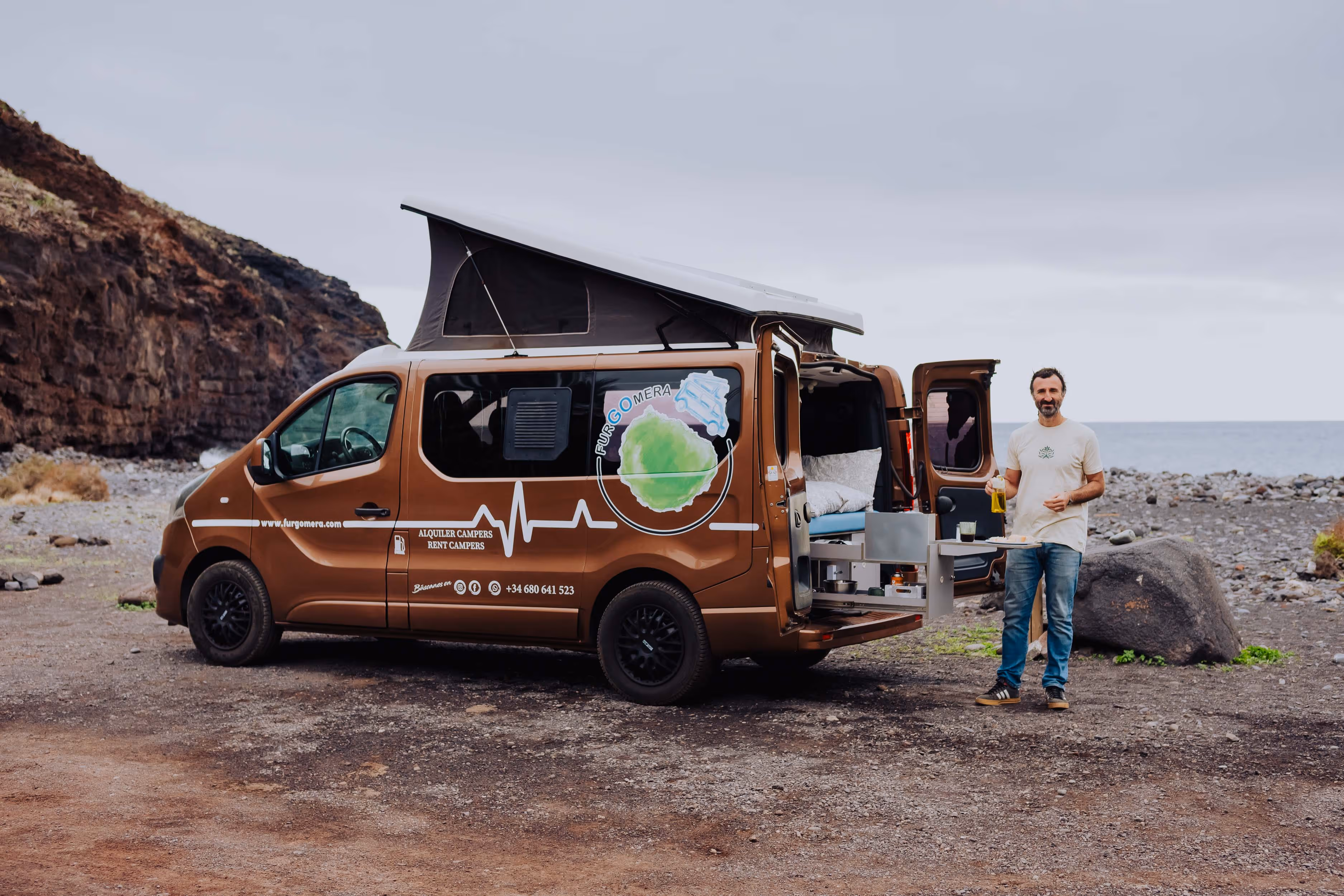Camper Arguamul con cocina exterior desplegada junto al mar