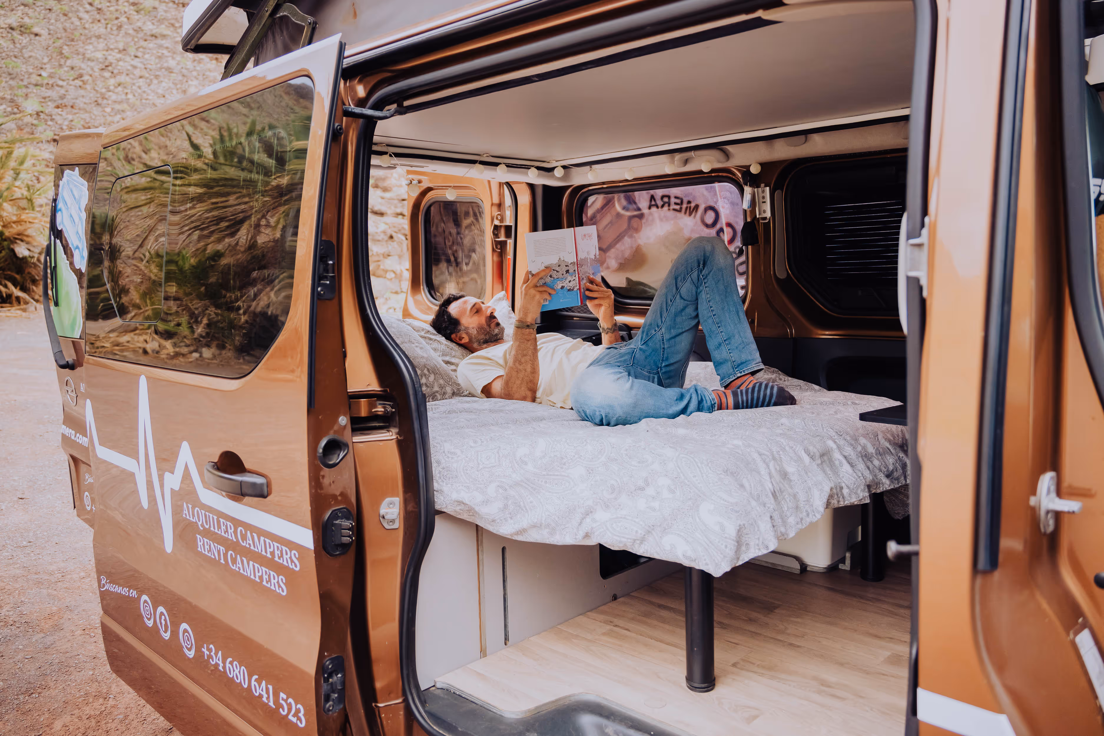 Interior de la camper Arguamul con cama preparada para descansar