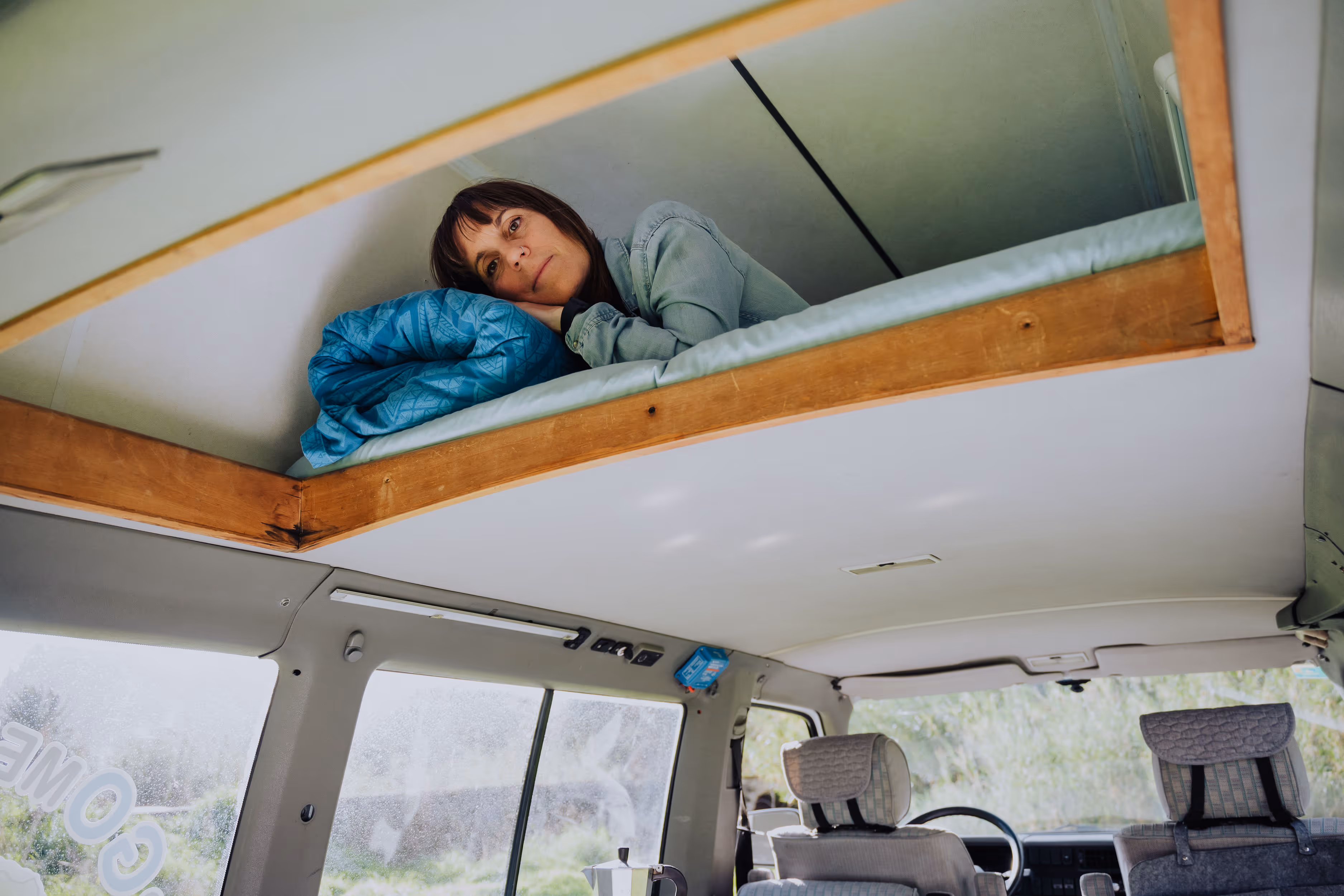 Viajera descansando en la cama superior de la camper Hipalan