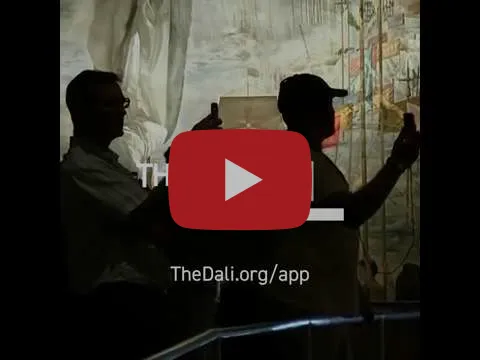 Video thumbnail of two visitors silhouetted as they hold phones up to a large Dali painting in a darkened gallery, labeled TheDali.org/app.