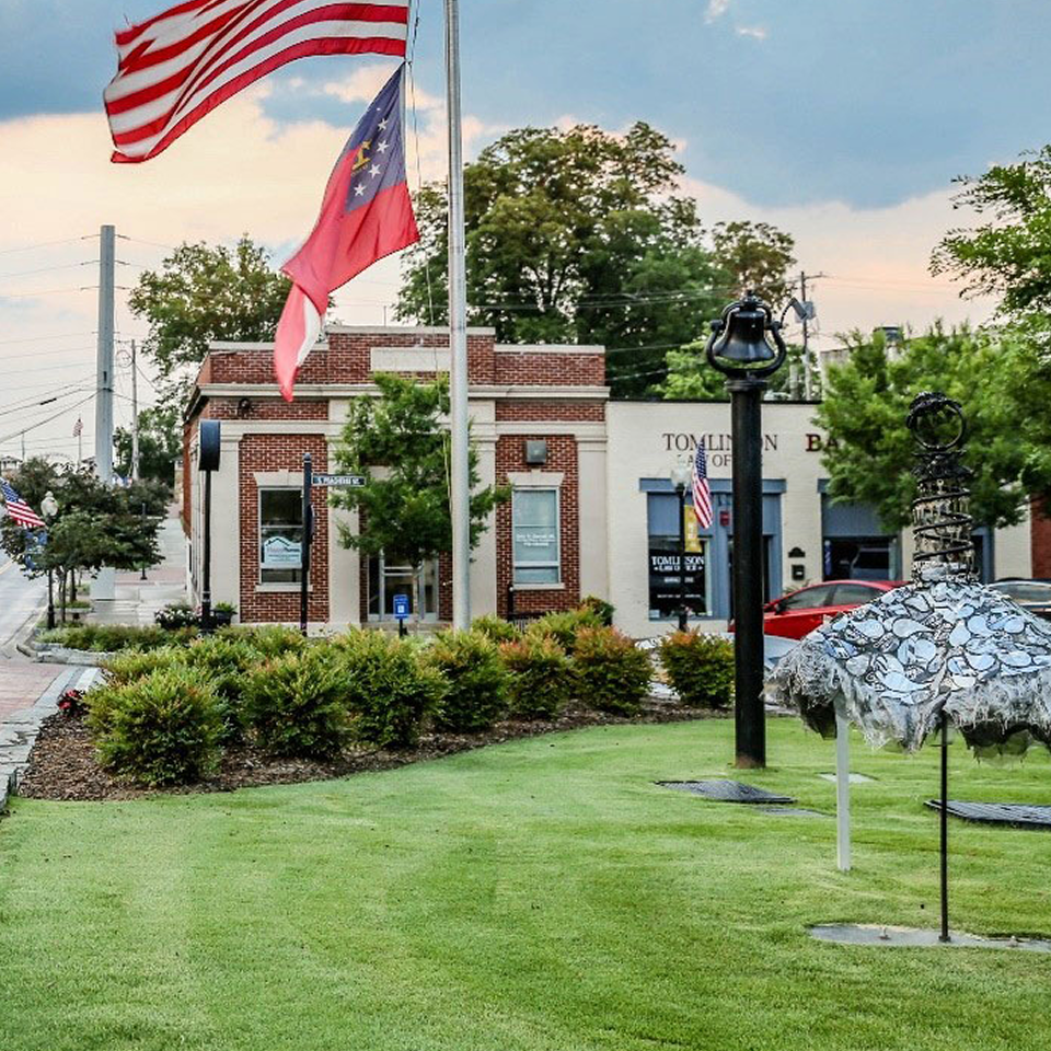 red brick building in norcross georgia with flag pole and flags flying in wind