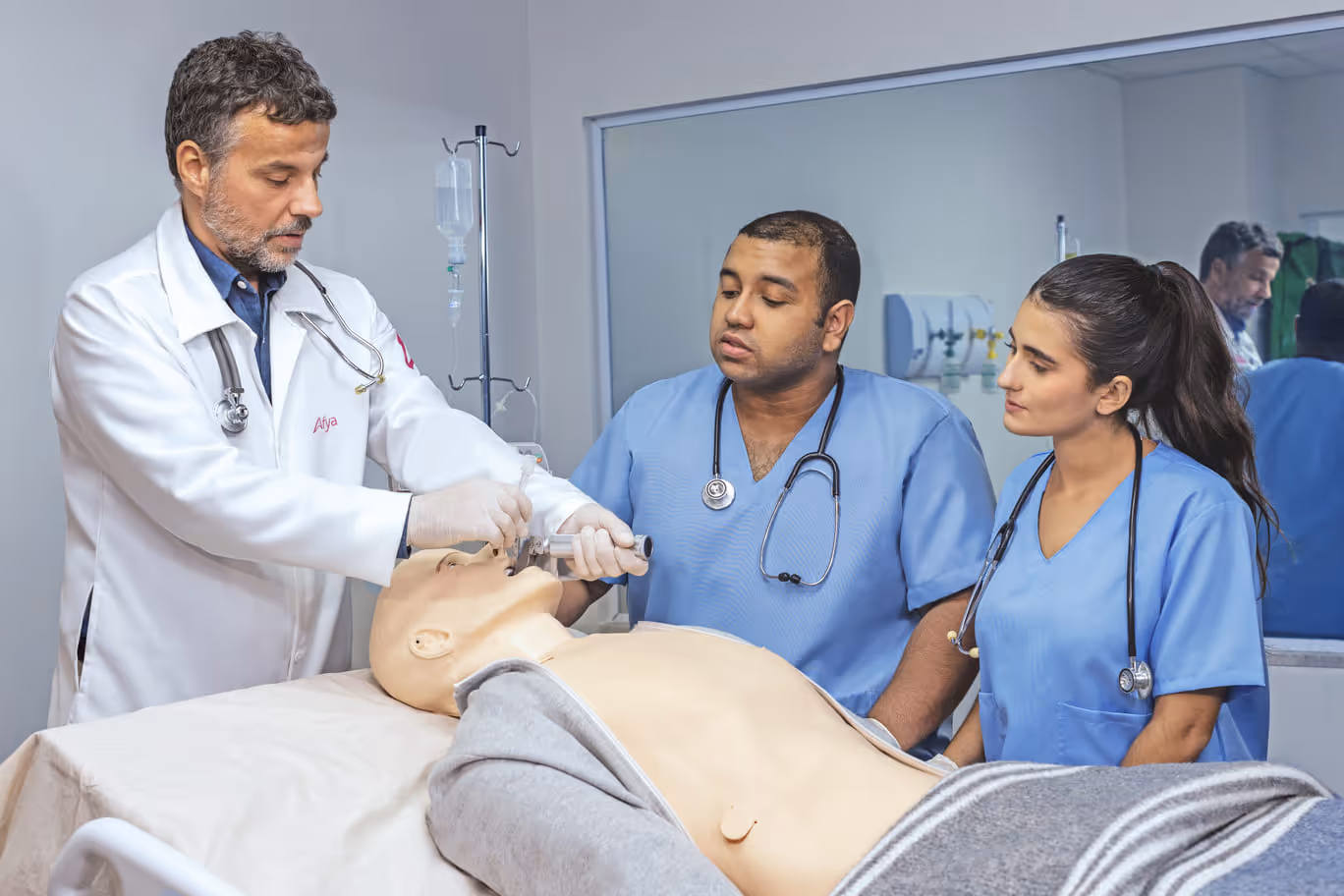 Professor dando instruções para dois alunos em um hospital