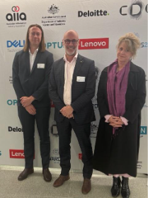 A group of people standing in front of a white wallDescription automatically generated