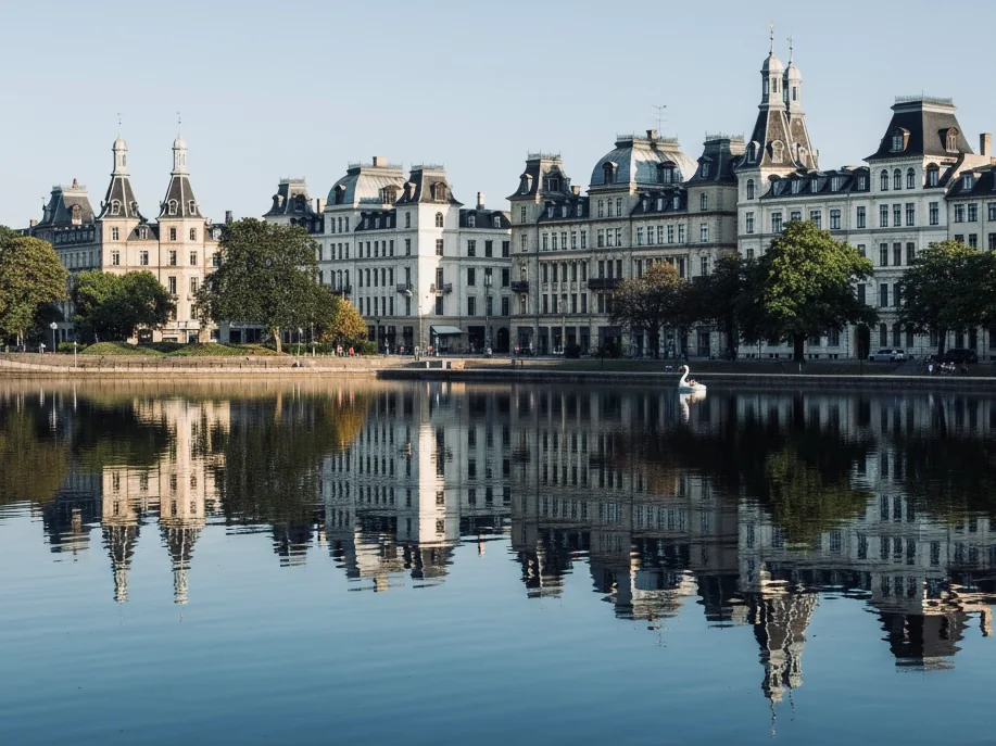 Udsigt over Søerne i København med klassiske, lyse bygninger langs vandet og spejling i den stille sø—området hvor SkatteInform holder til.