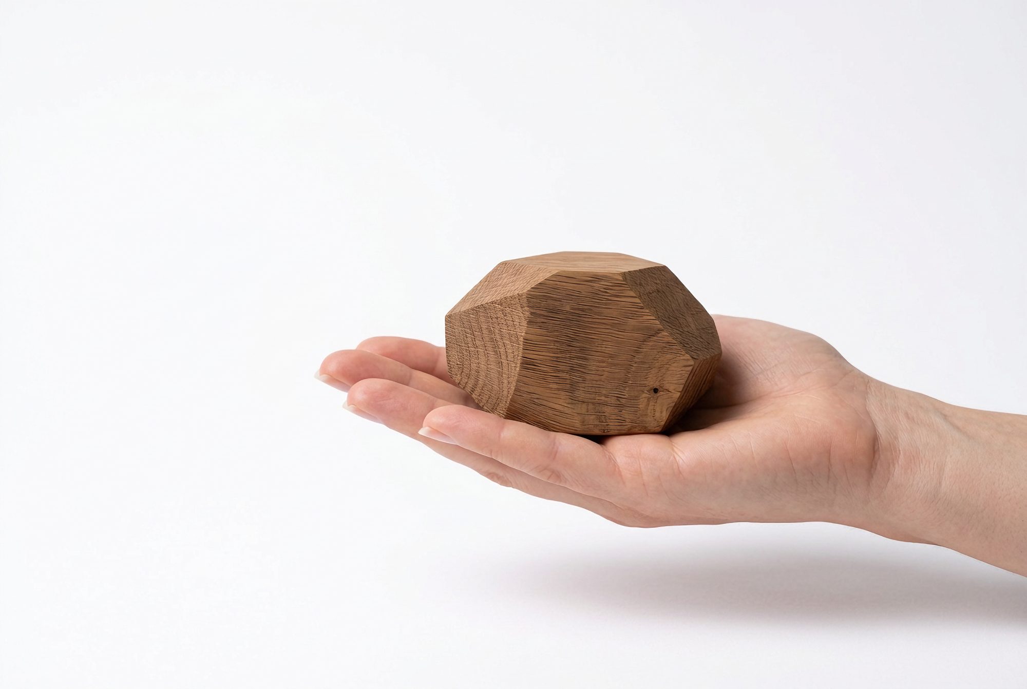 A sandblasted oak sample stone resting in an open hand
