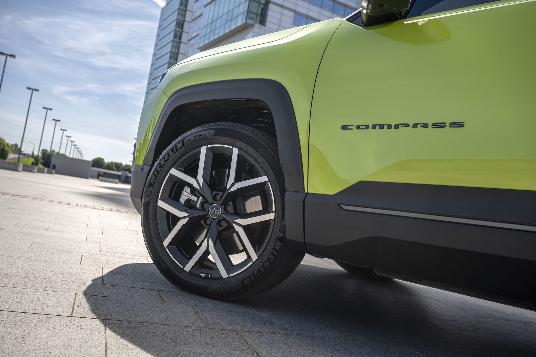 Leichtmetallfelge und Compass-Schriftzug des neuen Jeep Compass mit schwarzem Karosserieschutz, Detailaufnahme