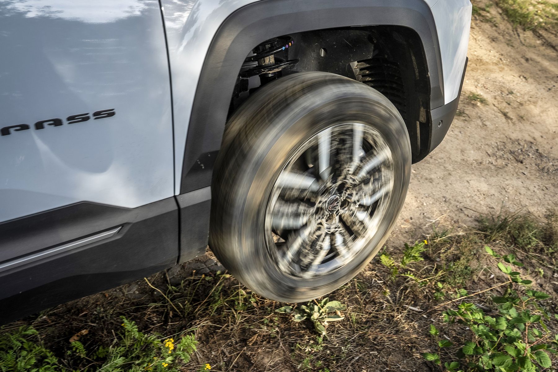 Drehendes Rad des Jeep Compass 4xe auf Schotter, Detailaufnahme