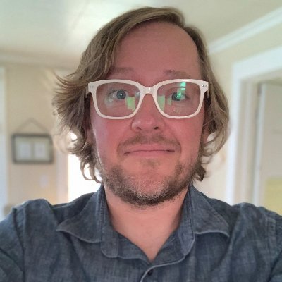 Nick is a while male with eye glasses, in a home environment.