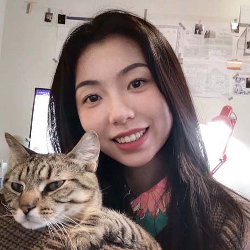 Jiangnan Xu is a Chinese girl with long black hair, smiling with a cat in the home background..