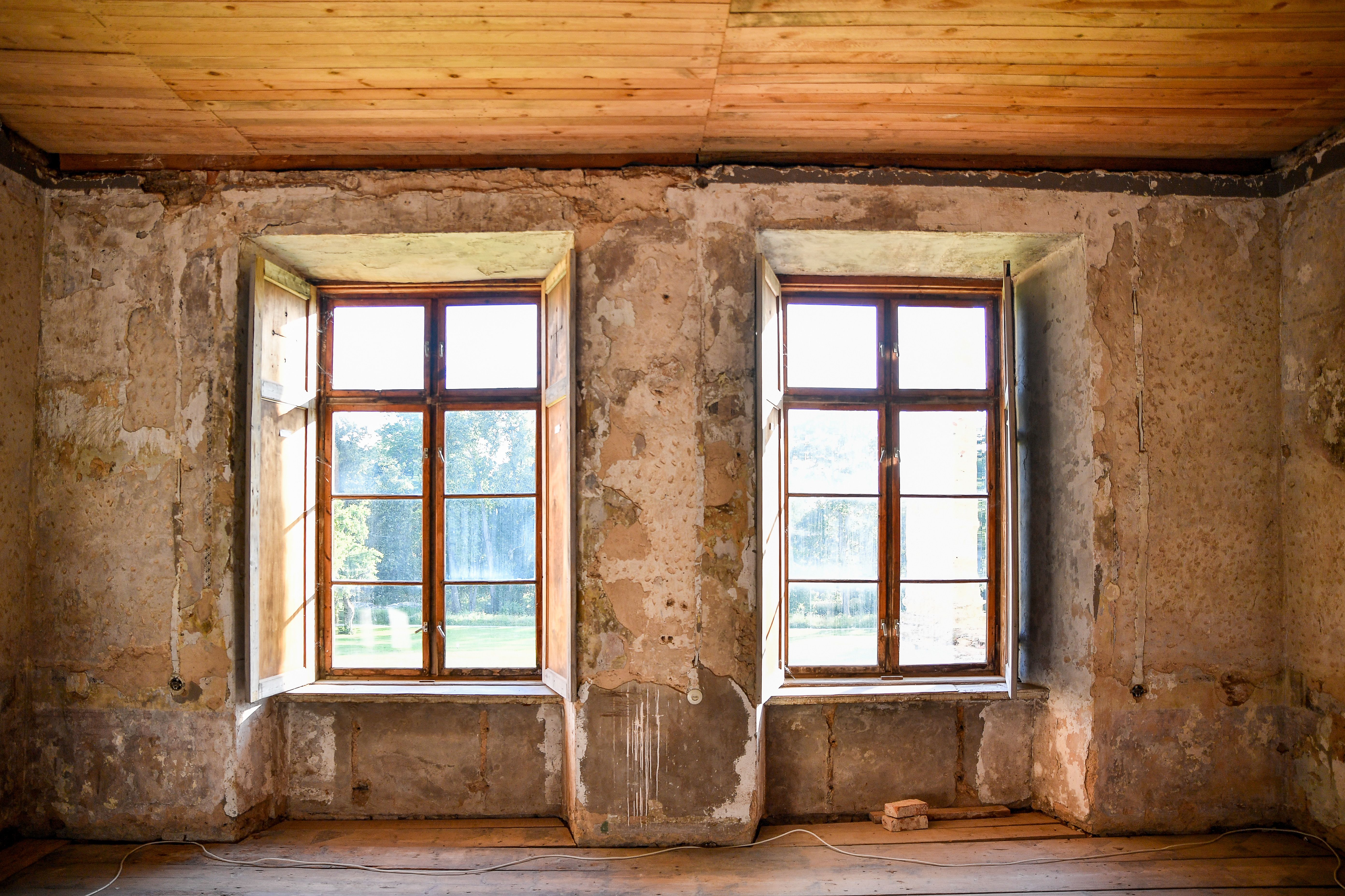Room in historic home with rustic windows, natural light highlighting the weathered walls