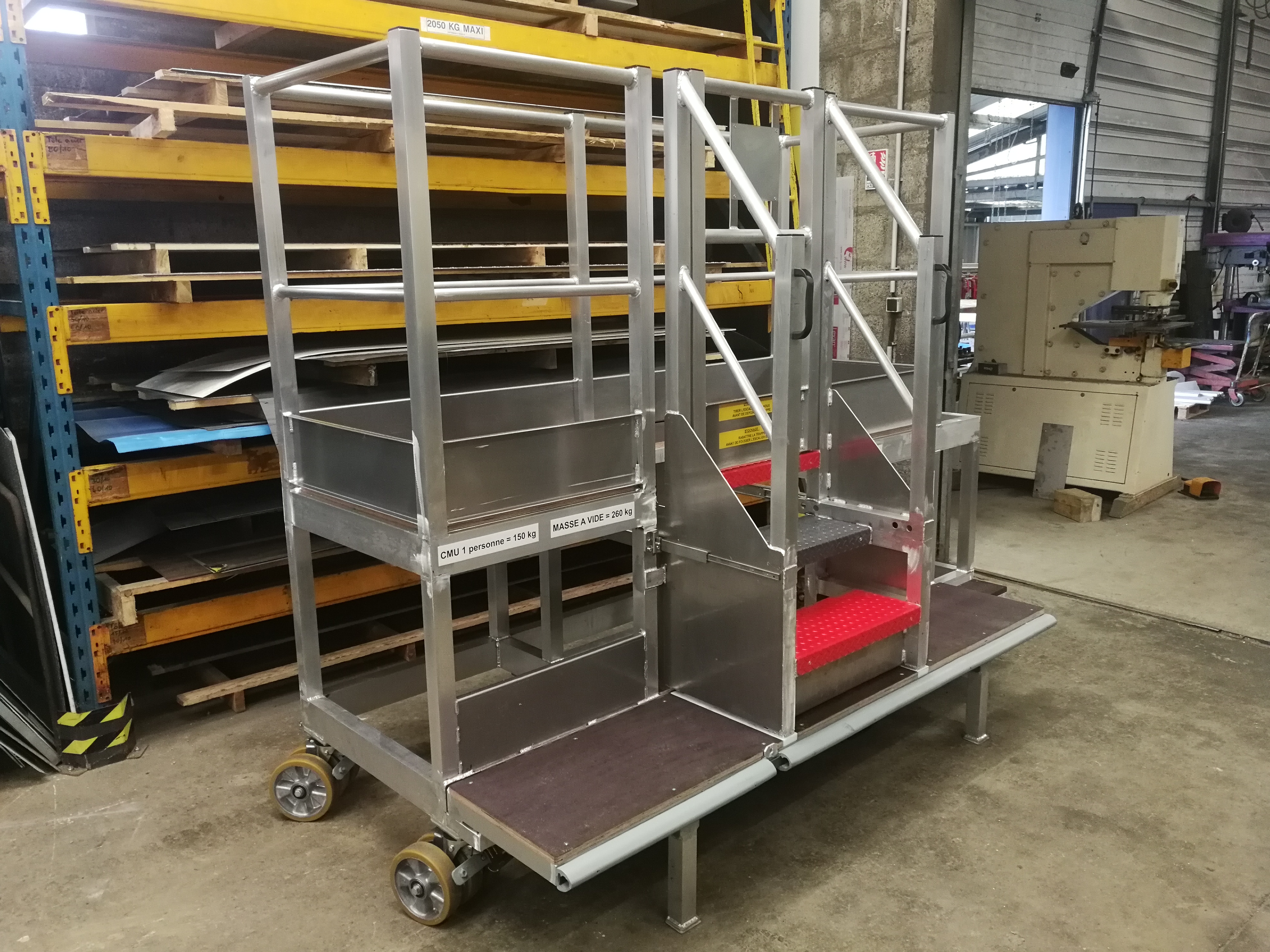 Plateforme de travail industrielle avec escalier rétractable intégré, sur mesure pour accès sécurisé