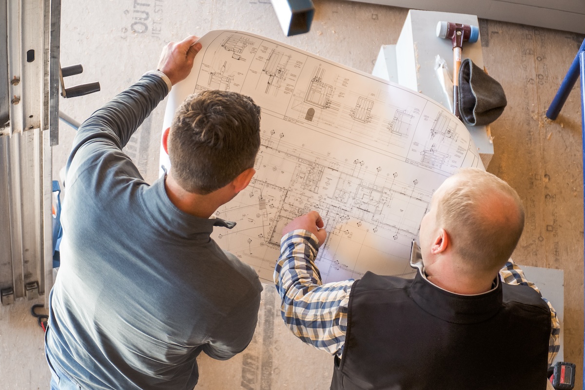 Tim O'Neill & Nick Bowes look over plans for a high end residential home their building on Cape Cod.