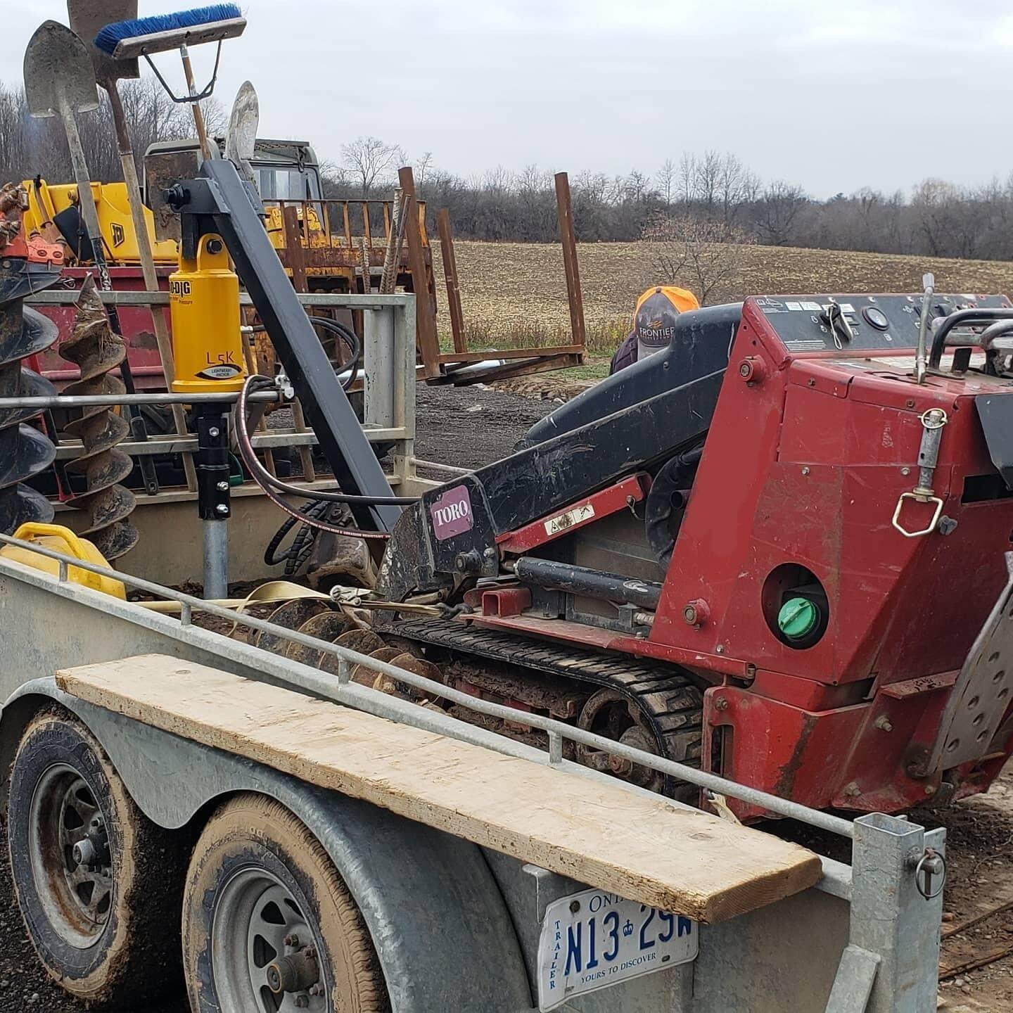 Tractor trailer loaded with farming equipment in a field