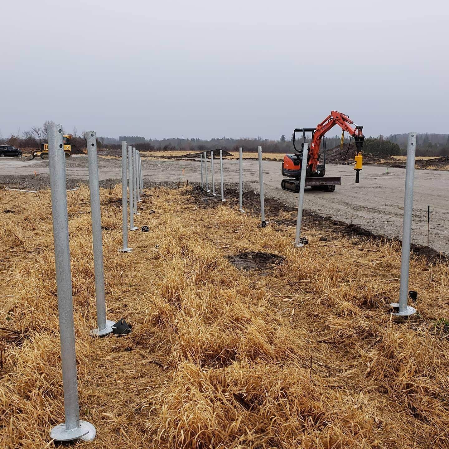 Tractor at construction site with poles