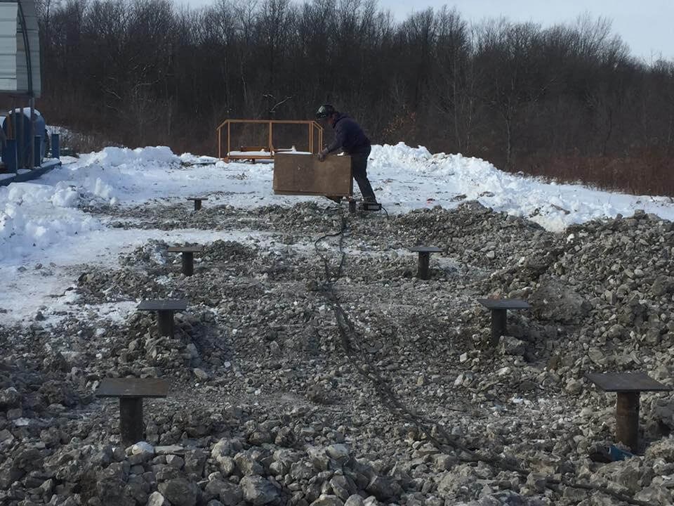 Man atop a rock pile under a clear sky