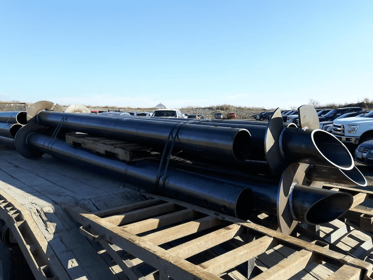 Stack of pipes on wooden pallet for helical pile foundations