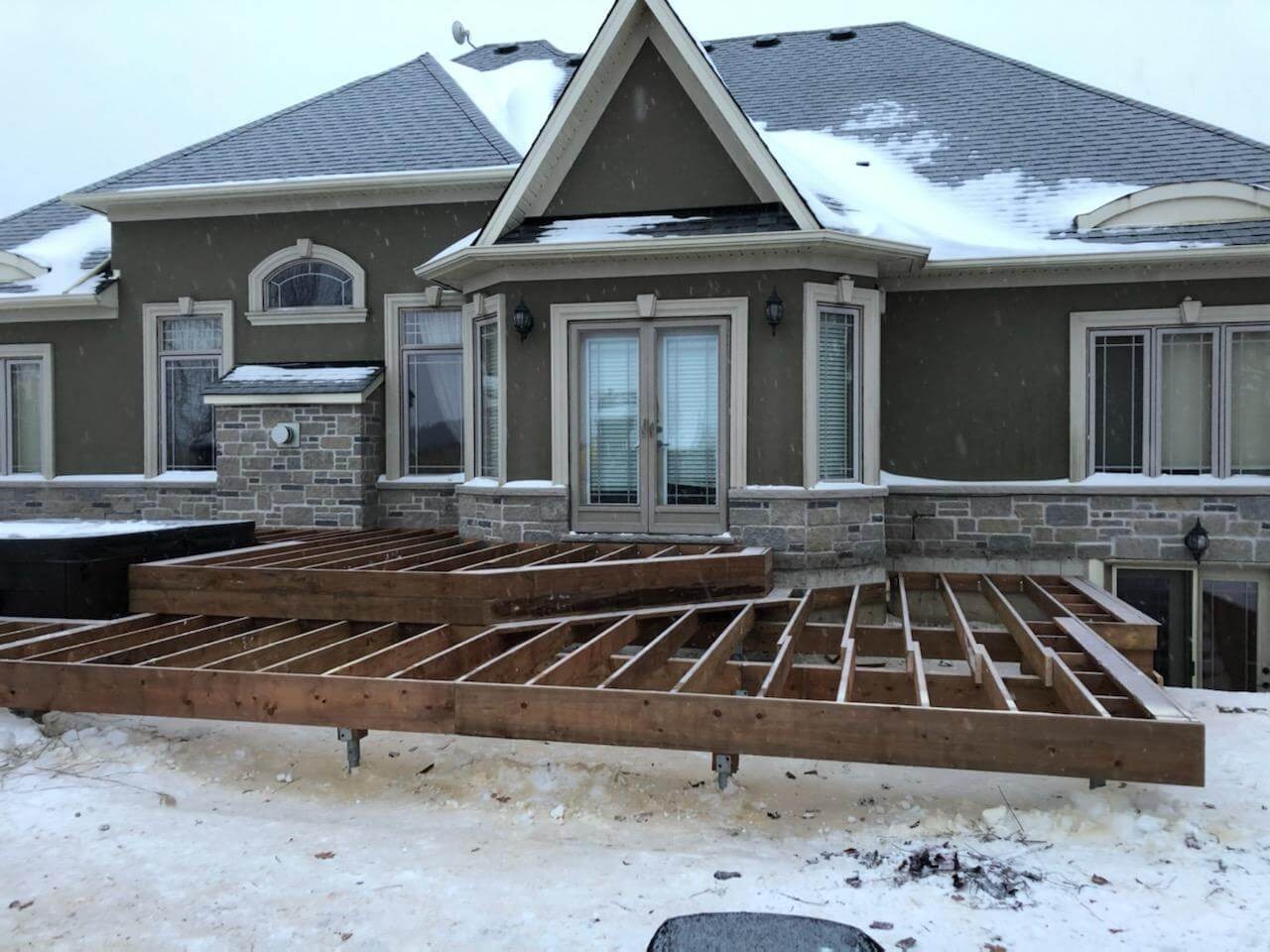 House with a wooden deck and snowy landscape